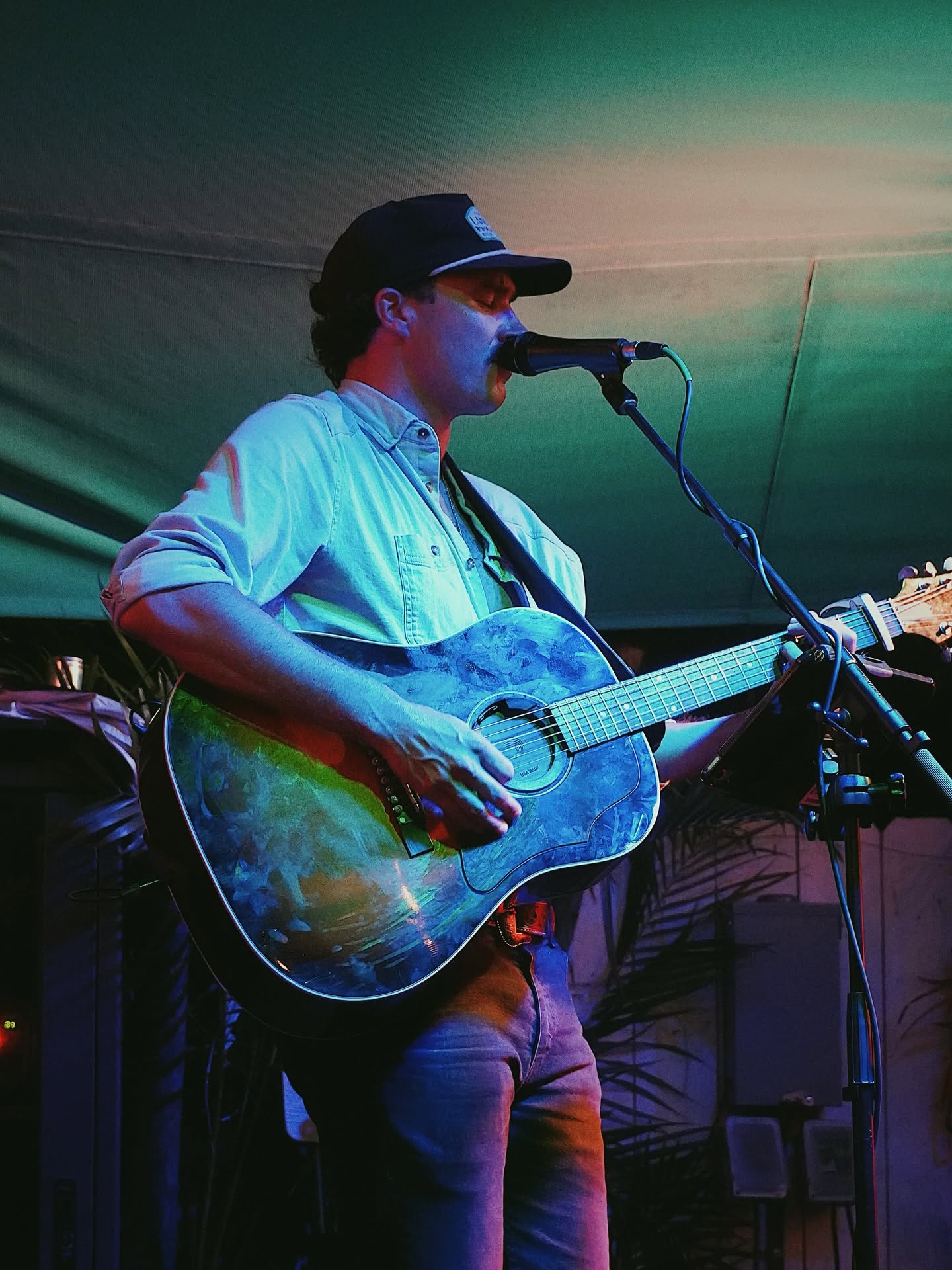 Pierce August singing and playing guitar during a live performance