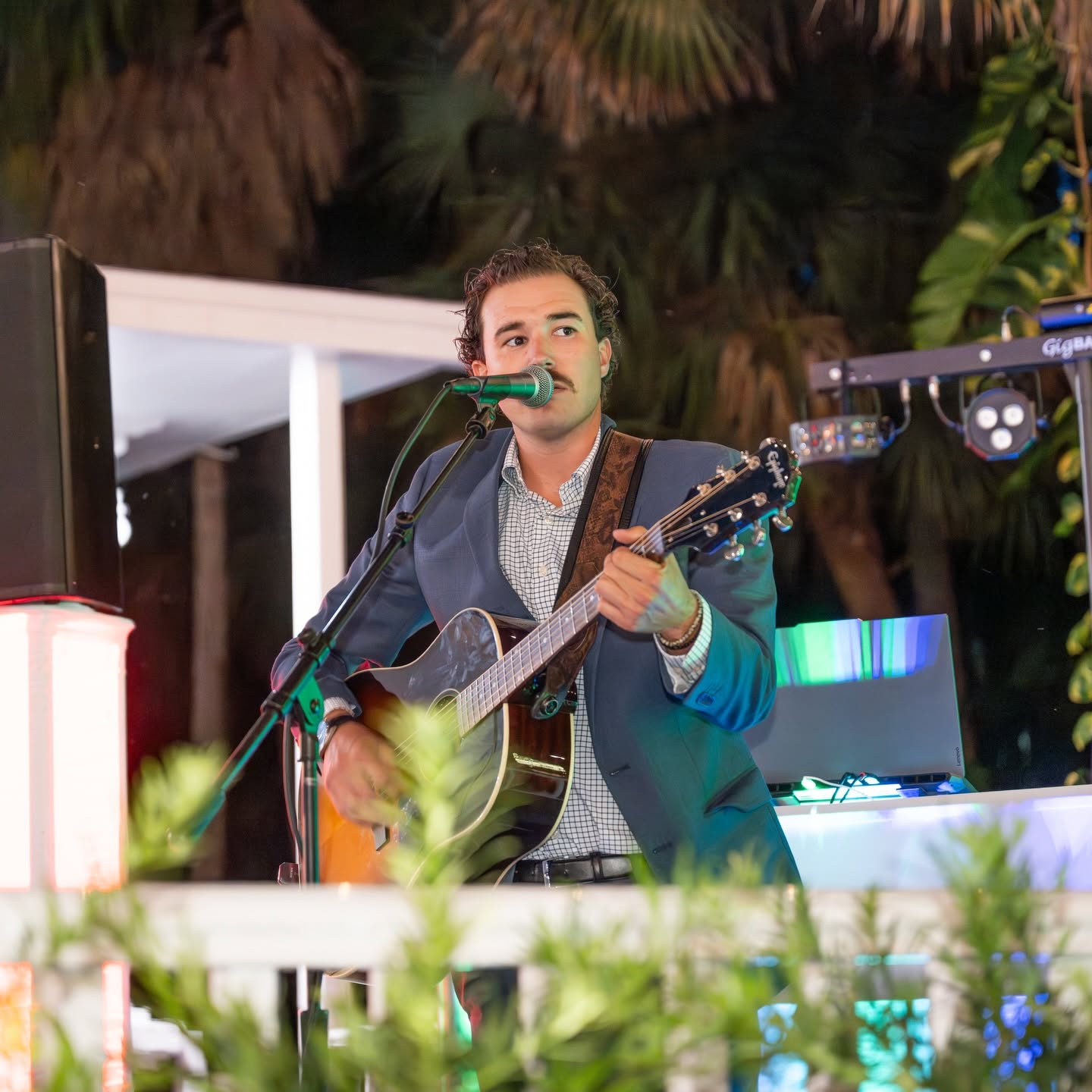 Pierce August performing in a suit jacket at a private event